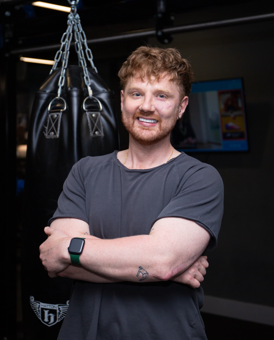 Andy Kirkpatrick, personal trainer in Belfast, standing with his arms folded in the gym